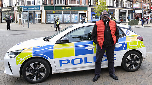 Ade Adeyemo in front of a West Midlands Police car